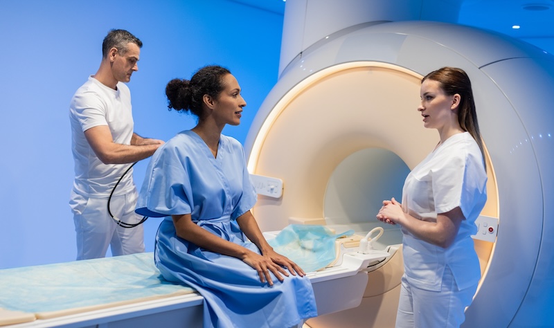 Doctor Preparing Patient For MRI Scan